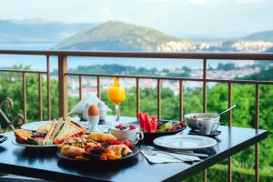 einen Tisch mit Teller mit Speisen auf dem Balkon in der Unterkunft Enastron View Hotel in Kastoria