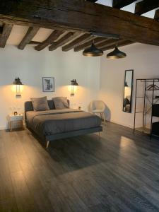 een slaapkamer met een groot bed in een kamer met houten vloeren bij Luxury Room in town house in Lunay