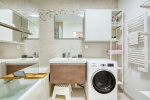 a bathroom with a washing machine and a sink at Le Fonction, meublé 4 étoiles, avec parking boxé in Aix-en-Provence