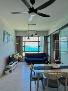 a living room with a blue couch and a ceiling fan at Kids Love It! Fantastic Seaview with Infinite Pool, 5min to jetty, Food Spot-MangoHouse2 in Kota Kinabalu +57 photos