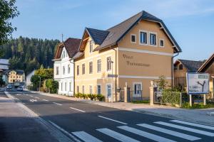 żółty budynek na poboczu ulicy w obiekcie Villa Theresienhof w mieście Rosegg