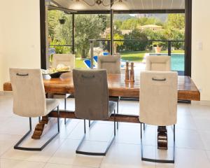 a dining room with a wooden table and chairs at Villa Quietude in Bagnols-en-Forêt