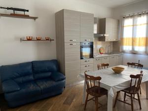 salon ze stołem i niebieską kanapą w obiekcie Alloggio con piscina a Sorso 3 kilometri dal mare w mieście Sorso