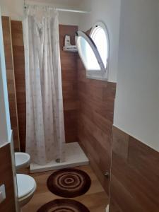 a bathroom with a shower with a toilet and a window at Appartamentino Sogno di Circe in San Felice Circeo
