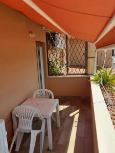 un tavolo e sedie su un portico con tetto arancione di Appartamentino Sogno di Circe a San Felice Circeo