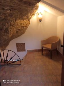 - une chambre dans une grotte avec une chaise et une lampe dans l'établissement CASA ENROCADA, à Setenil de las Bodegas