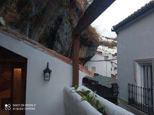 - un balcon avec vue sur une maison en pierre dans l'établissement CASA ENROCADA, à Setenil de las Bodegas