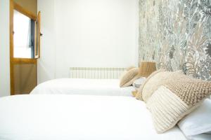 two beds in a room with white walls at Elegante Apartamento LAUD1 - Nuevo/Familia/Wifi/TV in Valladolid