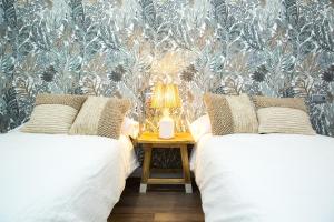 a bedroom with two beds and a table with a lamp at Elegante Apartamento LAUD1 - Nuevo/Familia/Wifi/TV in Valladolid