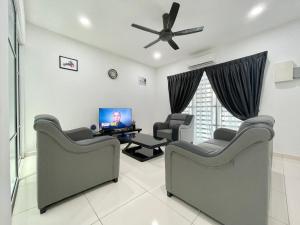 a living room with two chairs and a flat screen tv at Langkawi Cozy Holiday Home at Taman Simfoni by Zervin in Kuah