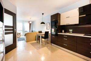 a kitchen with a table and a dining room at Wola Pleasure Place Apartment in Warsaw