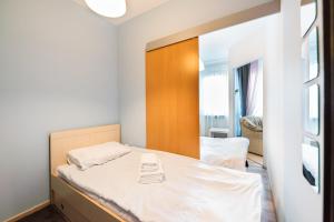 a small bedroom with a bed with a wooden headboard at Wola Pleasure Place Apartment in Warsaw