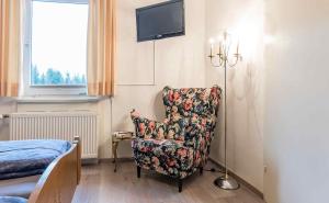 Pokój z krzesłem, telewizorem i łóżkiem w obiekcie Haus Schönblick w mieście Kniebis