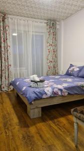 - une chambre avec un lit doté de draps bleus et de rideaux dans l'établissement The House, à Oradea