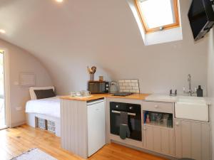 a kitchen with a sink and a bed in a room at Ash in Uttoxeter