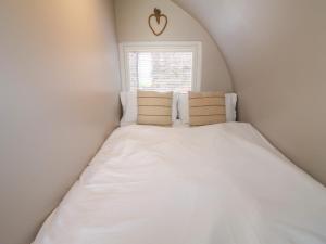 uma cama num pequeno quarto com uma janela em Ash em Uttoxeter