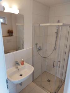 a bathroom with a glass shower and a sink at Apartment Traveller in Wackersdorf