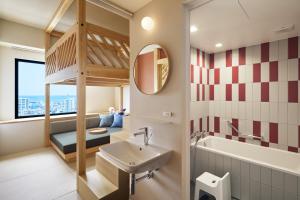 那霸的住宿－OMO5 Okinawa Naha by Hoshino Resorts，一间带双层床、水槽和镜子的浴室