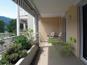 2 sillas y una mesa en el balcón de un edificio en 2P 4* 58m2 face au Lac, en Aix-les-Bains