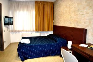 um quarto de hotel com uma cama, uma mesa e cadeiras em Piazza Dante em Taranto