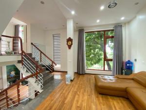 ein Wohnzimmer mit einem Sofa und einer Treppe in der Unterkunft Mint Homestay - Thanh Hóa in Thanh Hóa