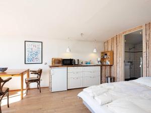 Cet appartement comprend une chambre avec un lit et une table ainsi qu'une cuisine. dans l'établissement Holiday home Bogense II, à Bogense