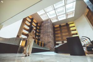 a woman standing in front of a building at The Strings by InterContinental, Tokyo, an IHG Hotel in Tokyo