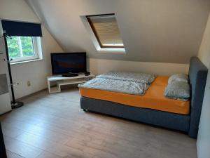 a bedroom with a bed and a flat screen tv at Apartmenthaus am Rennplatz in Bremen