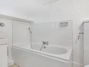 Lovely Heather House 1 double 6 single beds في توركواي: حمام أبيض مع حوض ومغسلة