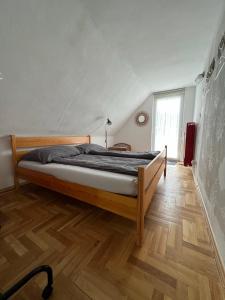 Cama grande en habitación con suelo de madera en Verandás Vendégház, en Balatonkenese