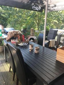 una mesa de madera con sillas y una sombrilla en el patio en Køge Bed & Kitchen, en Køge