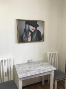 einen Tisch mit einem Bild einer Frau mit Hut in der Unterkunft Bonus in Winnyzja
