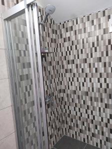 uma casa de banho com um chuveiro com azulejos castanhos e cinzentos em Secret garden no:01 em Famagusta