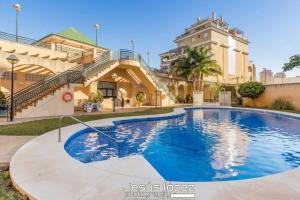 a large swimming pool in front of a building at Apartamento Calma Beach Home in Torremolinos