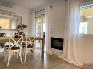 un comedor blanco con mesa y sillas en Apartamento Calma Beach Home, en Torremolinos