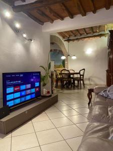 uma sala de estar com uma televisão e uma sala de jantar em Il Vicolo em Buti