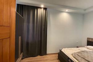 um quarto com uma cama e uma janela com uma cortina em Cheerful 3-bedroom villa with pool em Oganavan