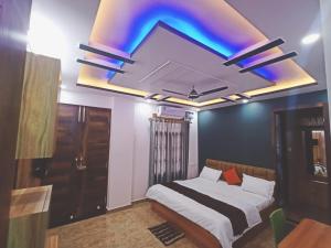 een slaapkamer met een bed en een televisie in het plafond bij SIDDHARTHA INN in Lucknow