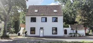 a white house with a bicycle in front of it at Apartmenthaus am Rennplatz in Bremen