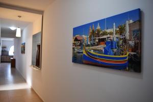 une peinture d'un bateau suspendu sur un mur dans l'établissement Da Vinci 3 bedroom Apartment, à Mellieħa