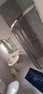La salle de bains est pourvue de toilettes blanches et d'un lavabo. dans l'établissement Da Vinci 3 bedroom Apartment, à Mellieħa
