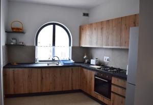 d'une cuisine avec des placards en bois, un évier et une fenêtre. dans l'établissement Da Vinci 3 bedroom Apartment, à Mellieħa
