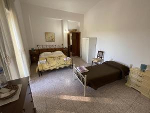 a bedroom with two beds and a dresser and a bed sidx sidx sidx sidx at B&B Caterina in Biccari