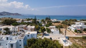 - une vue aérienne sur une ville avec des maisons blanches et l'océan dans l'établissement Hermes Luxury Suites, à Naxos Chora
