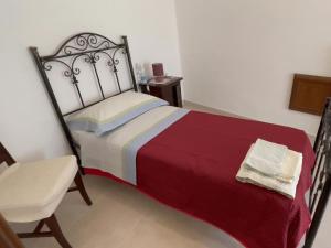 a bedroom with a large bed and a chair at B&B Caterina in Biccari