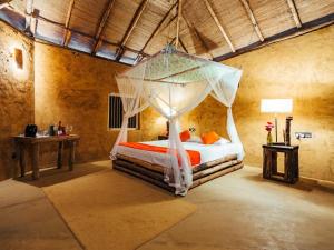 a bedroom with a bed with a canopy at The Saraii Tree Lodge in Tissamaharama
