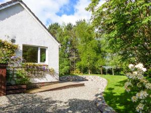 a house with a garden and a walkway at Bo Nan Taigh Cottage in Aberfoyle