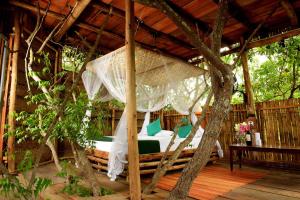 a bed in a pavilion with a hammock at The Saraii Tree Lodge in Tissamaharama