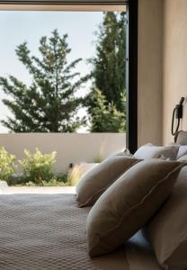 una fila de almohadas sentadas en una cama frente a una ventana en Ananta Blue Residence, en Argassi