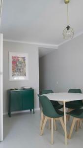 a dining room with a table and green chairs at At home, in the Heart of Sitges in Sitges